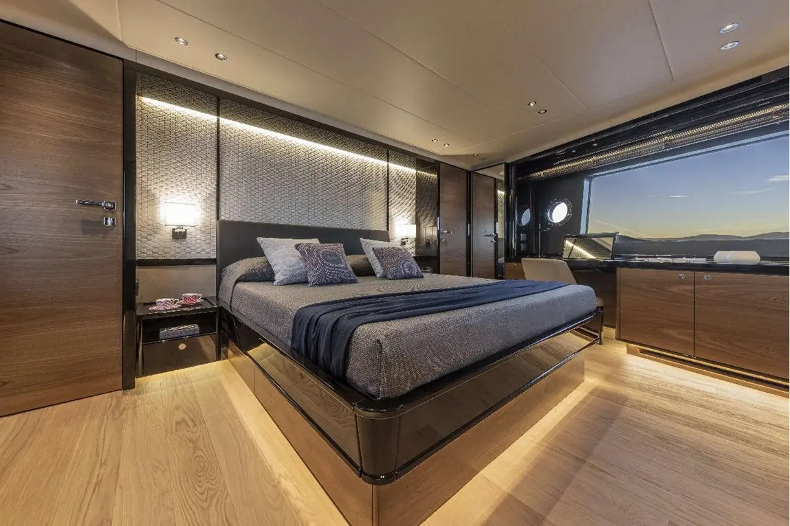 Modern yacht bedroom featuring a large bed, stylish decor, wooden finishes, and a scenic window view.